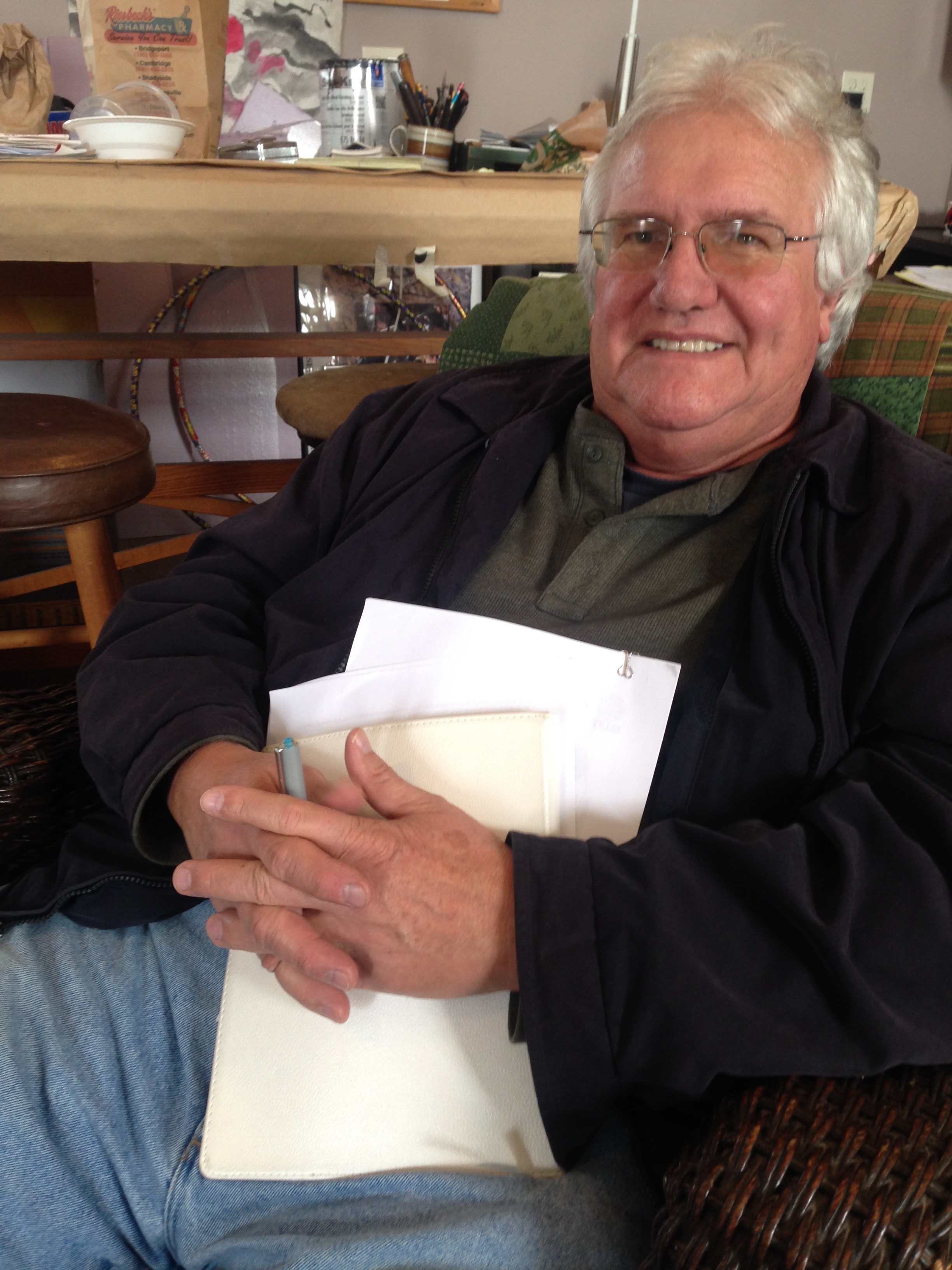 Smiling older man holding notebook and papers
