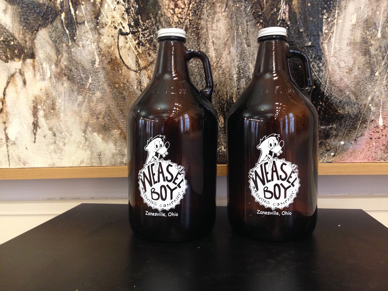 Two brown beer growlers with brewery logo