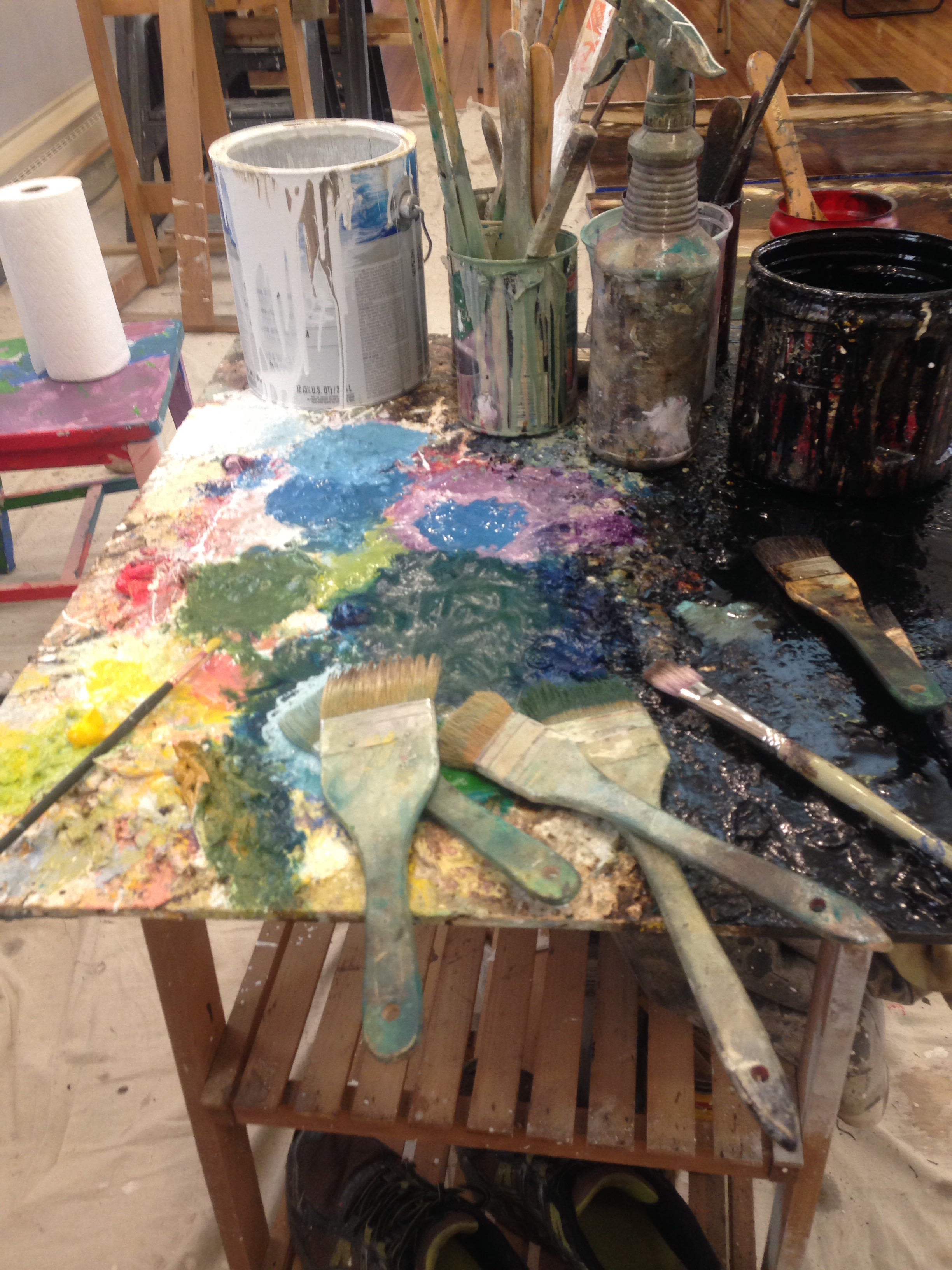 Paint-splattered worktable with brushes and jars