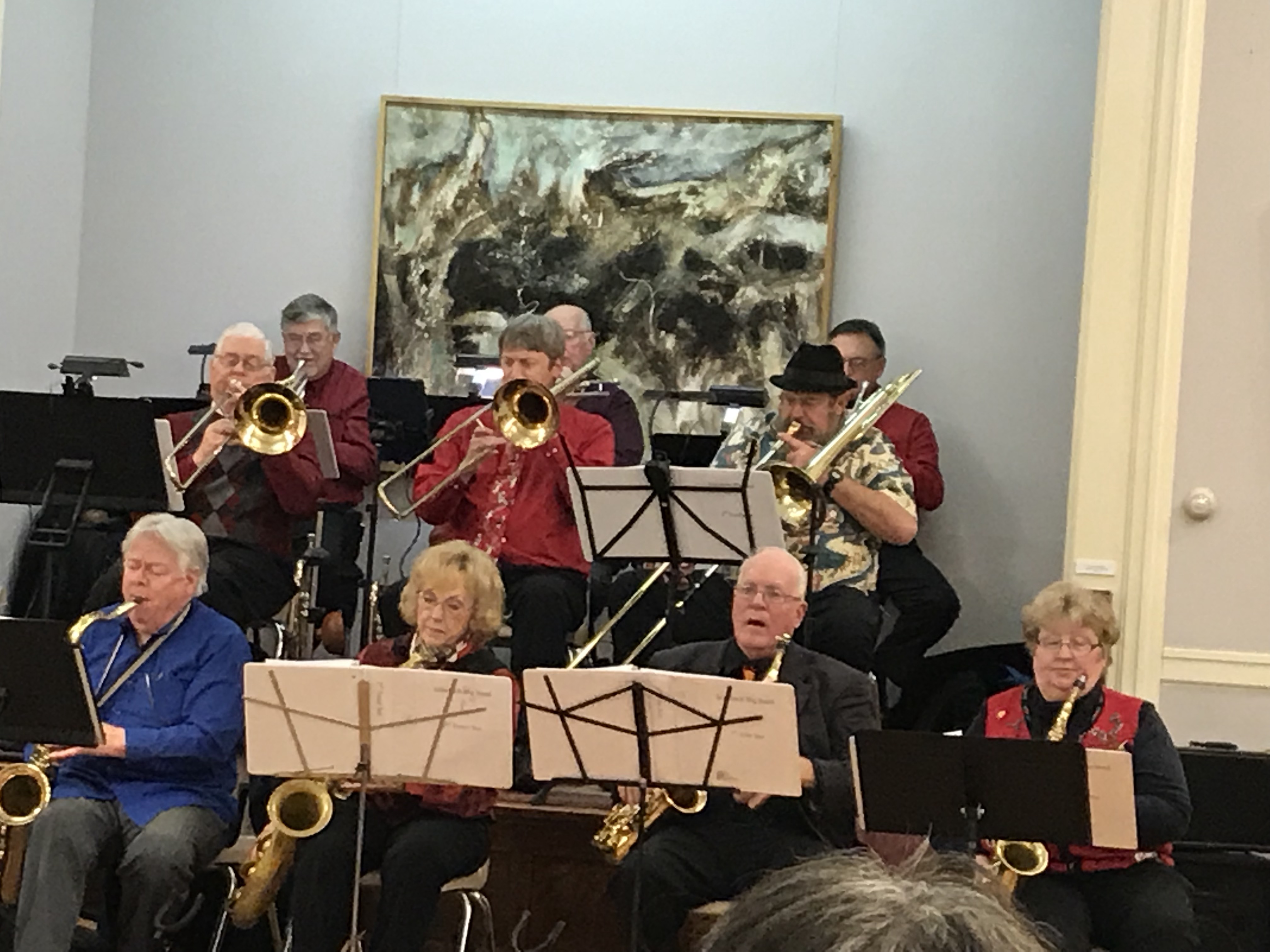 Seated band playing saxophones and trombones