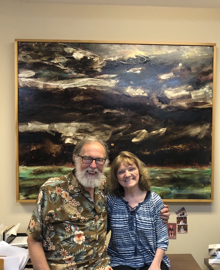 Smiling older couple in front of painting