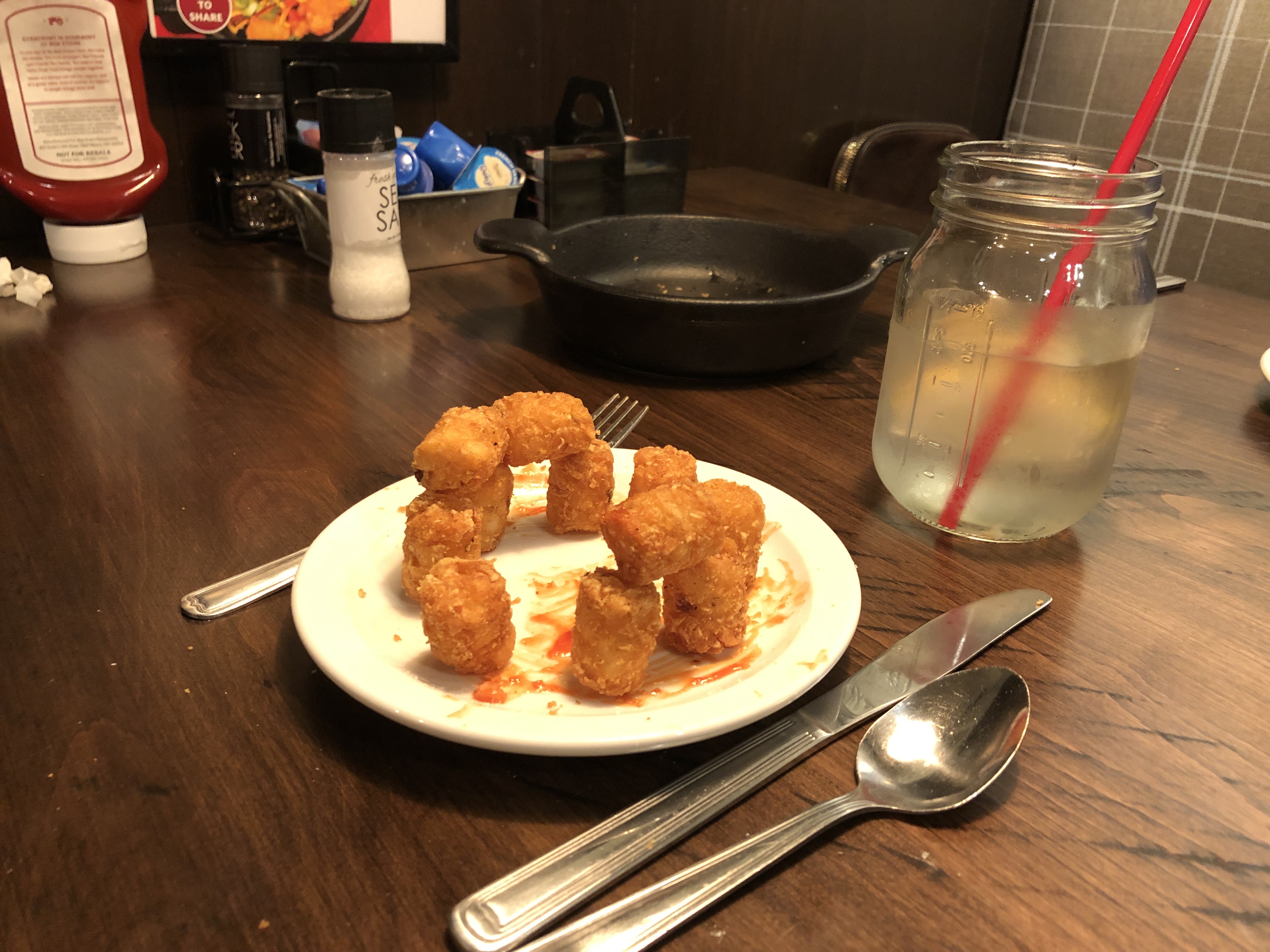 Crispy tater tots on plate with utensils