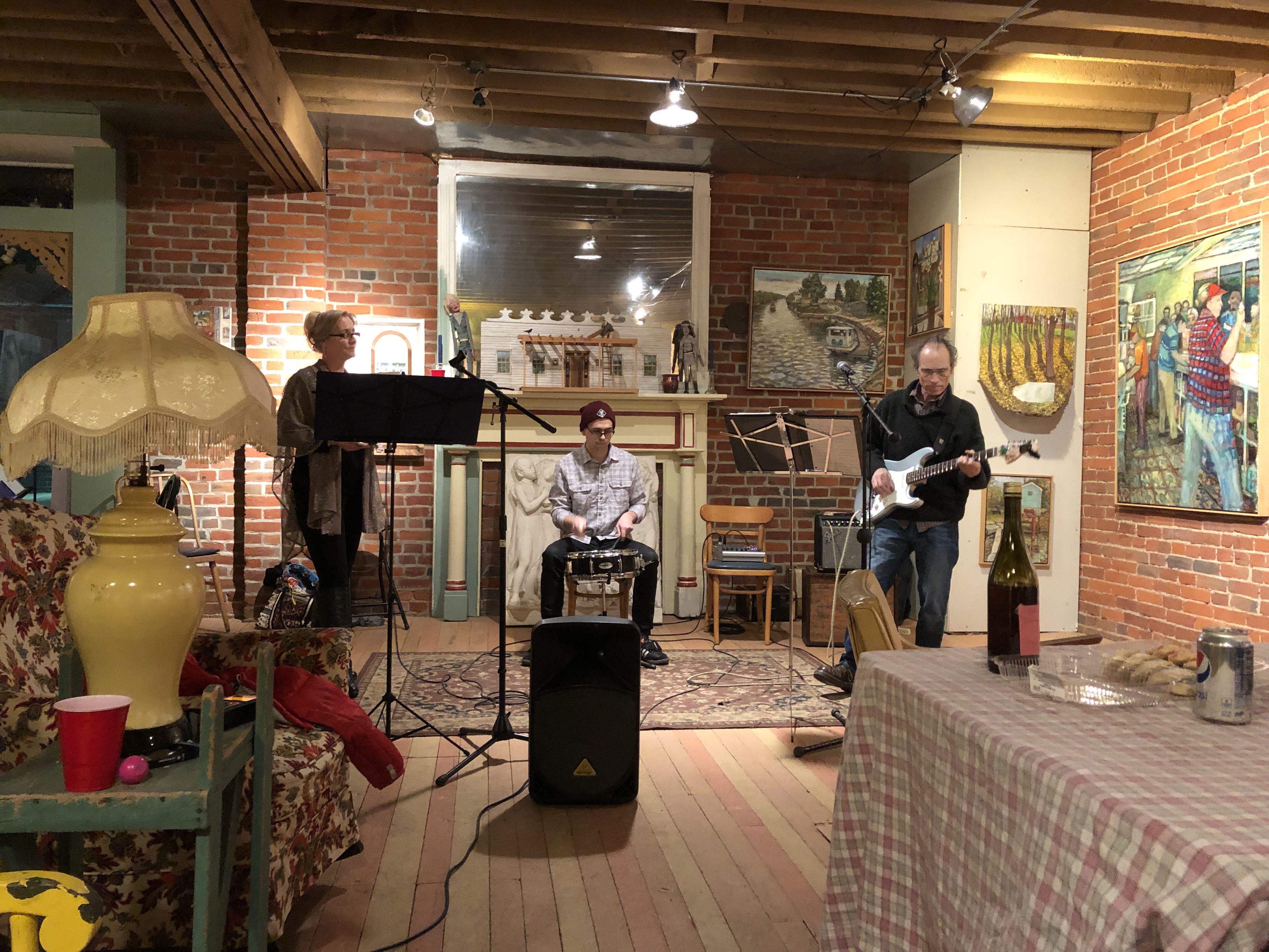 Three-piece band performing in cozy art gallery