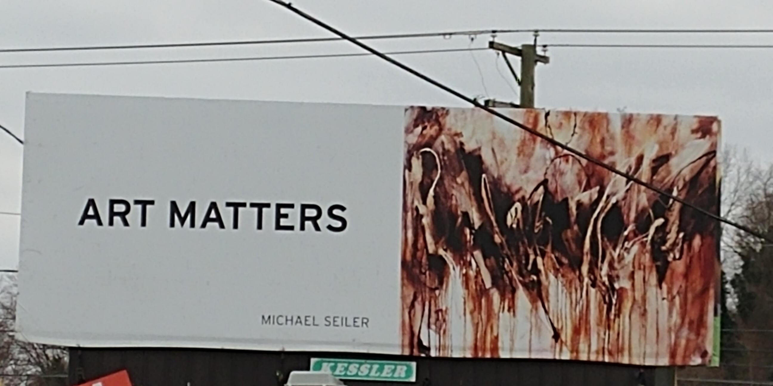 Billboard reading ART MATTERS beside abstract painting
