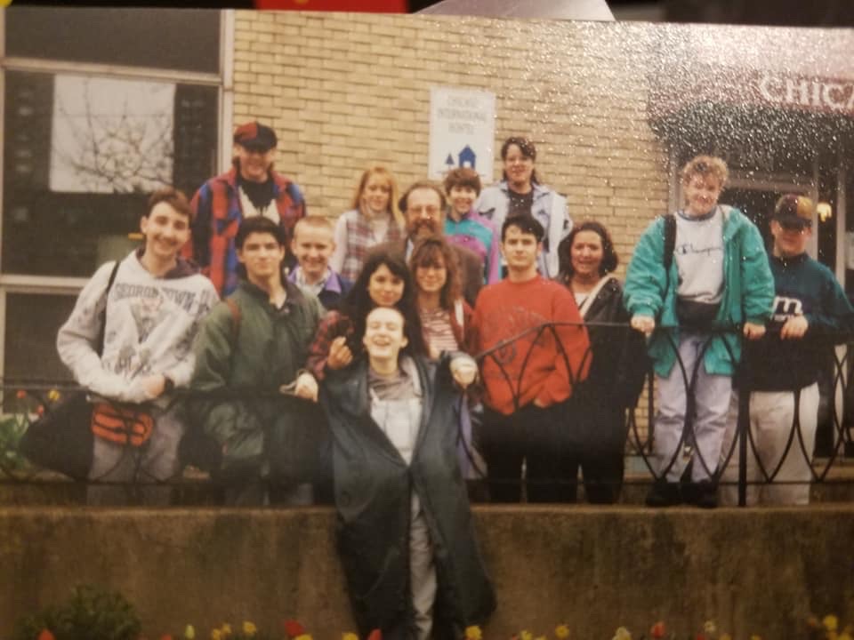 Smiling group of people outdoors by brick building