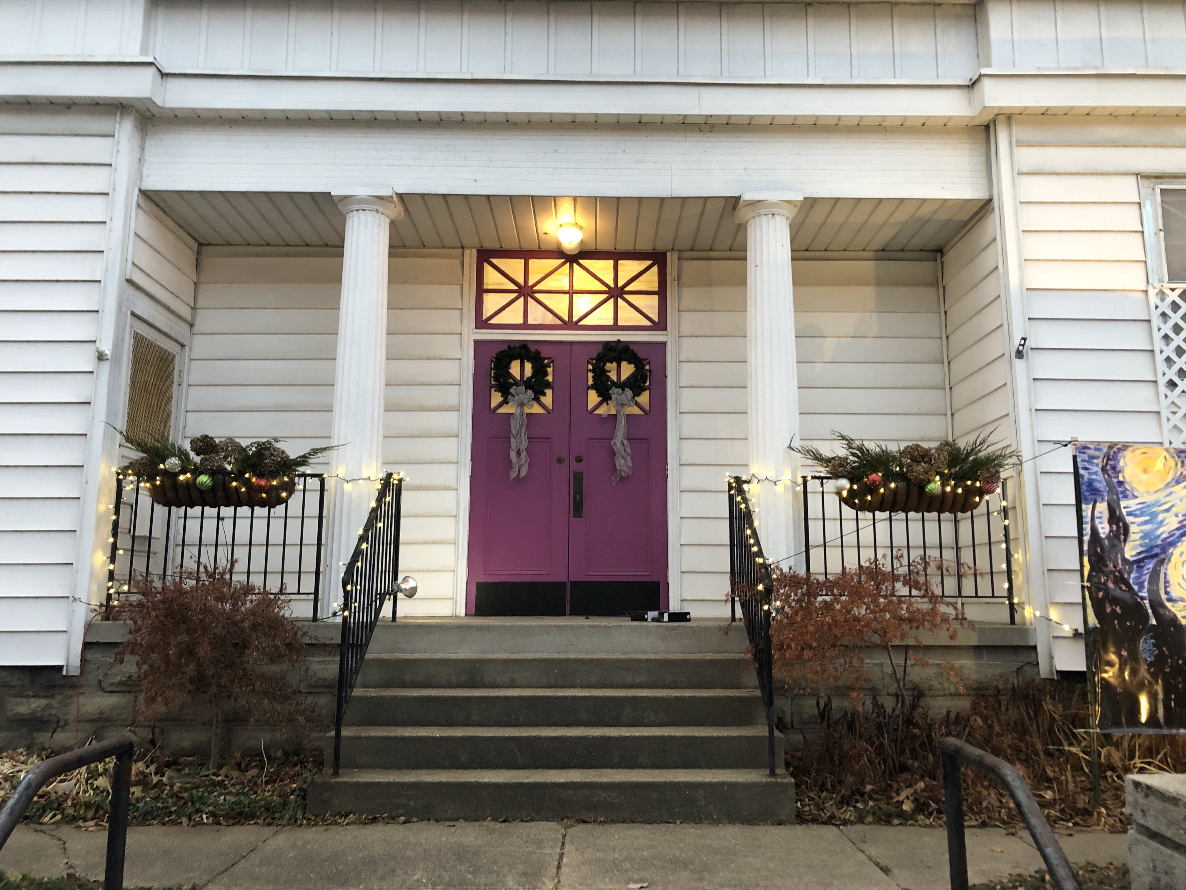 Purple double doors with wreaths and lights