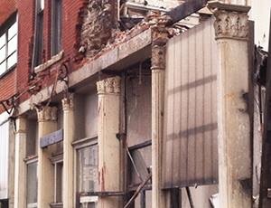 Dilapidated brick storefront facade with classical columns